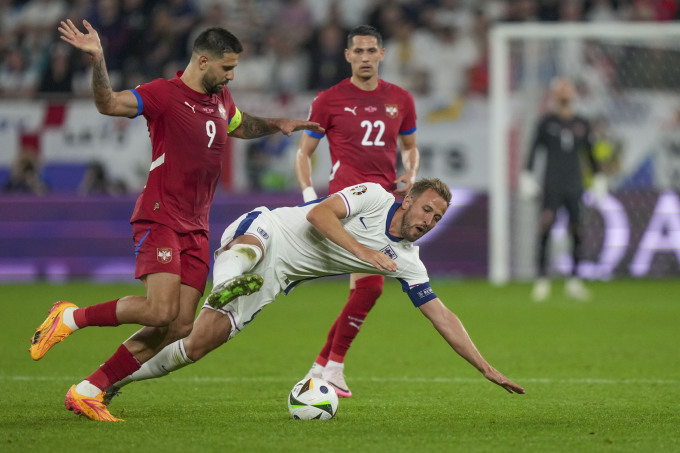 Tiền đạo Anh Harry Kane (áo trắng) ngã sau pha tranh chấp với Aleksandar Mitrovic trong trận thắng Serbia 1-0 ở lượt đầu bảng C Euro 2024 trên sân Veltins Arena, Gelsenkirchen, Đức ngày 16/6/2024. Ảnh: AP.