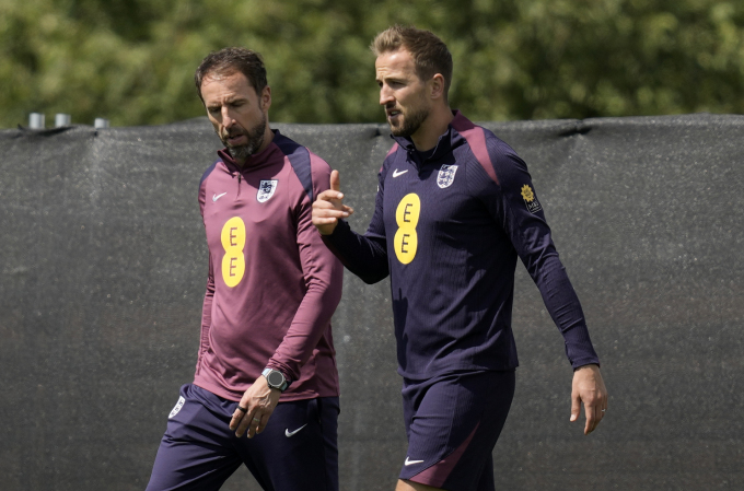 HLV Gareth Southgate (trái) và Harry Kane trao đổi khi vào sân tập của tuyển Anh ở Blankenhain, Đức, ngày 22/6. Ảnh: AP